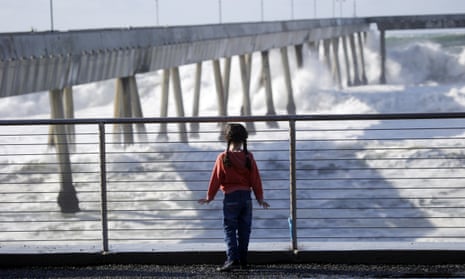 Eliki Bastow, 6, visiting from Cambridge, England, watches waves crash on the municipal pier Friday, in Pacifica, California.