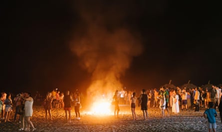 People around the bonfire on the beach for the festival of San Juan.