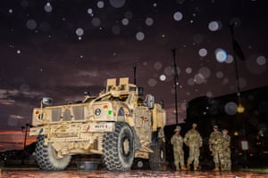 Soldiers stand by an armoured vehicle