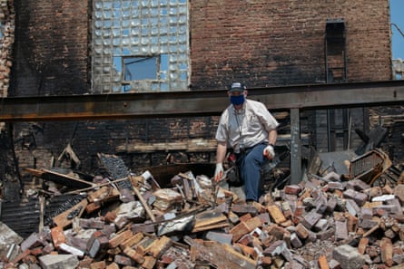 A man sifts through a destroyed building in the Uptown neighborhood of Kenosha.