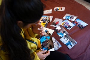 Nazira looks through photographs of her family and friends in and around her village, which were taken last year.