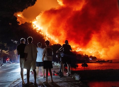 People look at a wildfire on the Adriatic coast near Omis