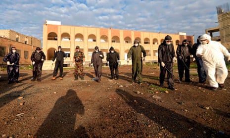 Security personnel disinfecting an area outside a security headquarters in Sanaa.