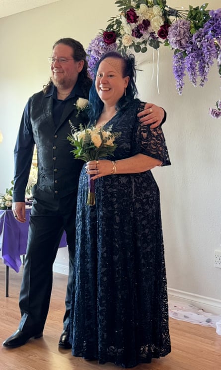 Susan Hayes in a navy lace dress with Craig in a navy brocade waistcoat, shirt and trousers at their wedding in 2025.