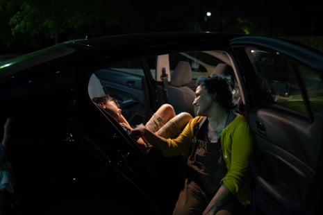 A woman caresses her son in a car at night