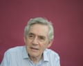 Headshot of British politician Gordon Brown in pale shirt against burgundy background
