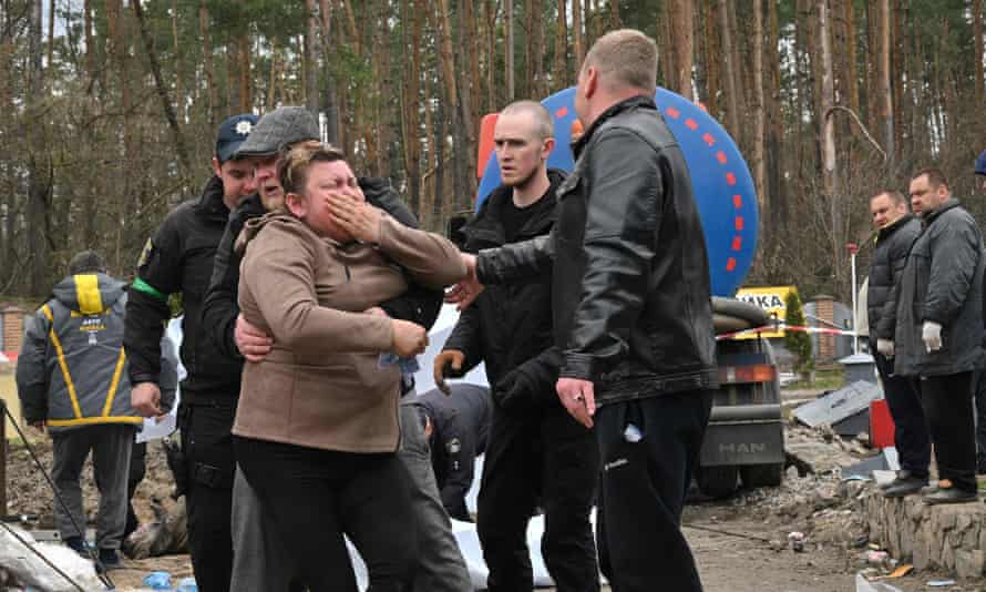 A Ukrainian mother reacts after the body of her son was discovered in a manhole at a petrol station on the outskirts of Buzova.