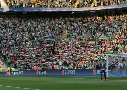 Celtic fans from the Green Brigade hold up large Palestinian flags during the Champions League qualifier between Celtic and Hapoel Beer Sheva.
