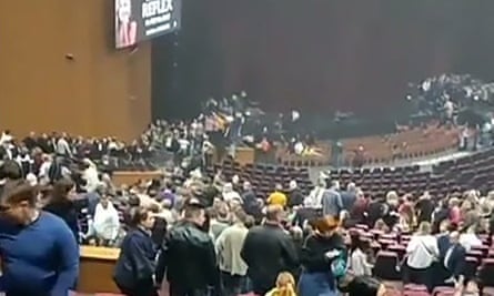 Video still showing chaotic scenes at the concern hall