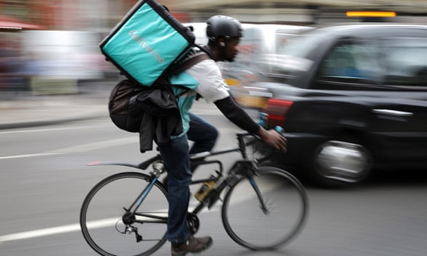 A Deliveroo rider on a bicycle.