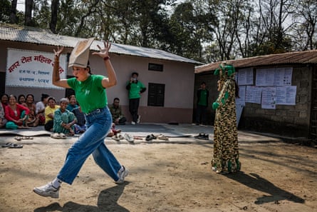 A woman in a makeshift tiger mask pretends to be a tiger. Another woman in a camouflage outfit stands next to her