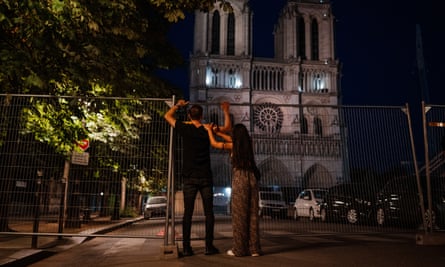 A glimpse of the Notre Dame Cathedral through a metal barrier.
