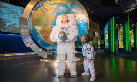 Cardboard cutout of astronaut Tim Peake in front of the National Space Centre’s giant globe display. A child in space costume looks on.