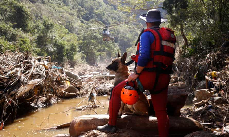 A search and rescue team member looks for bodies with the help of a dog.