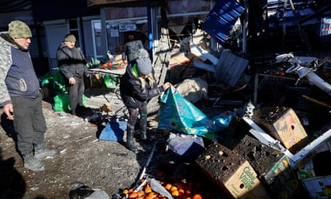 People remove debris at a food market in Donetsk following a missile strike