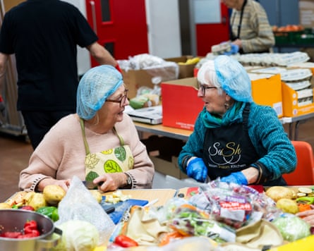 Two women chat and chop vegetables