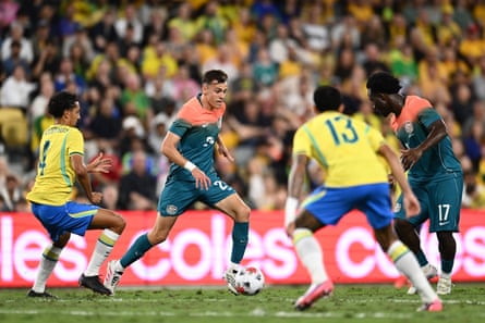 Paul Okon-Engstler runs with the ball past a Brazil player with Nestory Irankunda nearby in the first friendly in Townsville