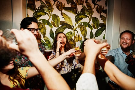 a group of friends doing shots at a bar