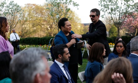 A White House aide attempts to take the microphone from Yamiche Alcindor of PBS as she questions Trump in the Rose Garden.