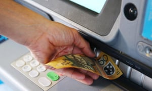A customer withdraws a 50 Australian dollar banknote from an ATM