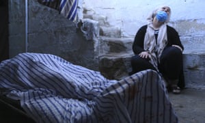 A relative cries by the body of a woman killed in shelling by the Turkish army in the town of Qamishli, Syria.