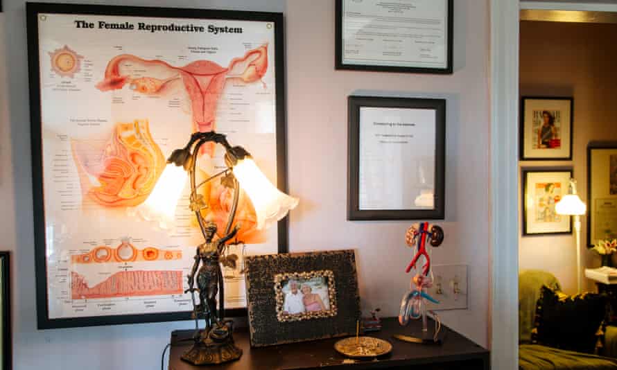 Diagrams and models of male and female reproductive systems sit next to incense and a photo of Dr Runels’ parents.