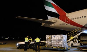 Los trabajadores del aeropuerto descargan los pallets del primer envío de la vacuna Moderna Covid-19 a su llegada a Australia