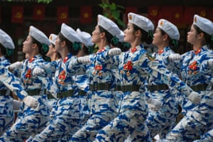 Female armed soldiers in blue camouflage uniforms on parade