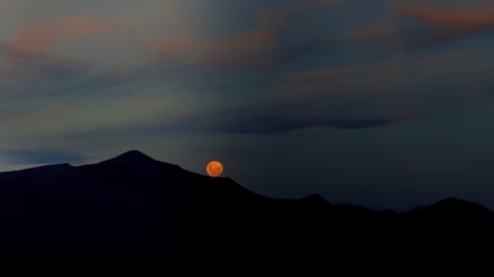 The moon rising over a mountain