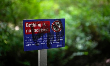 Blue sign warning people against bathing in river