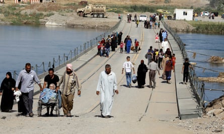 Displaced Iraqi residents cross a military pontoon bridge in western Mosul.