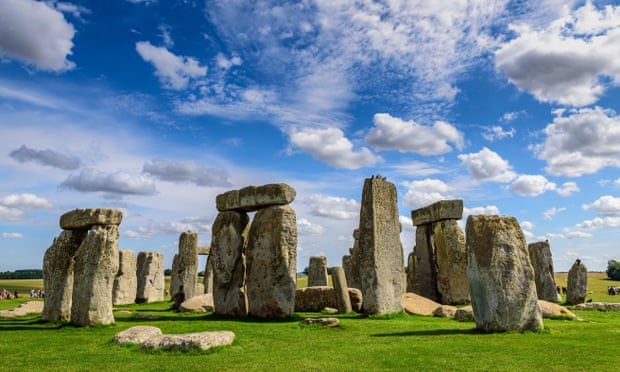 Stonehenge, against a bright blue sky with light clouds