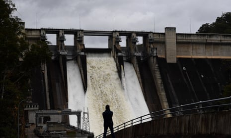 A person watches on as the Warragamba Dam spillway is seen outflowing in Warragamba, in South West Sydney