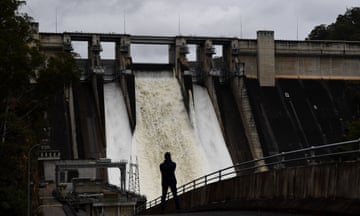 A person watches on as the Warragamba dam spillway is seen outflowing in south-west Sydney in 2021