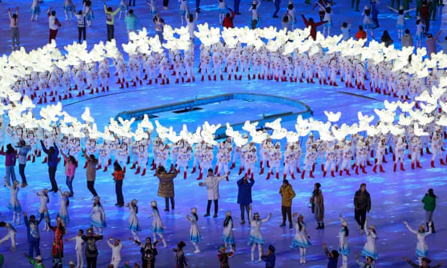 Performers hold up doves at the opening ceremony.