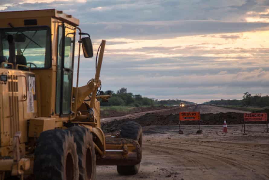 A digger sits on a wide dirt road