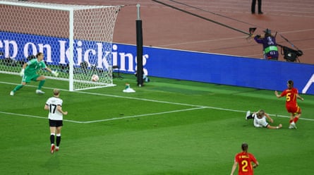 Aitana Bonmatí squeezes her shot past Ann-Katrin Berger at her near post.