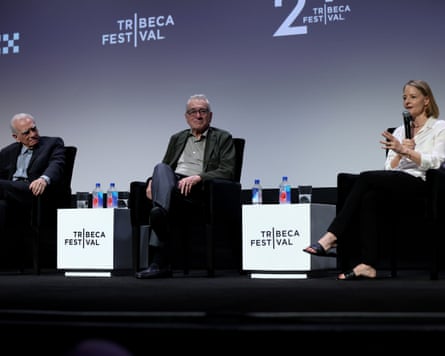 Two men and woman speaking on stage