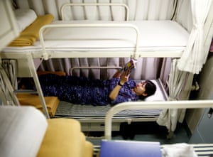 A woman lies on the lower bunk of a bed