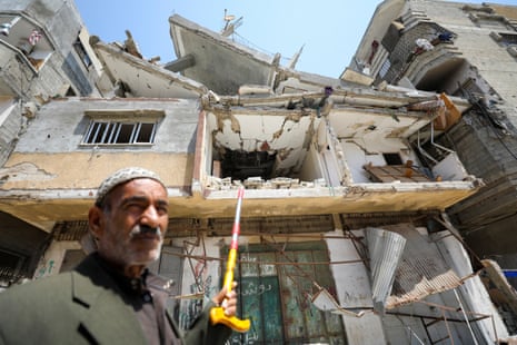 Ali Oroq’s grandson Zein died from his injuries after he was hit by an aid package airdropped on Gaza. Ali is pictured here pointing with a walking stick at his grandson's former home which was destroyed by an Israeli airstrike.