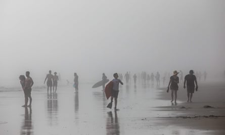 People enjoy the beach through afternoon fog in Huntington Beach, California, on 25 April.