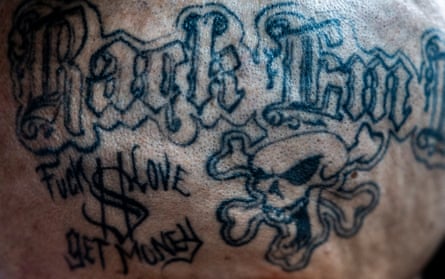 Close up detail of a tattoo which includes a skull and crossbone
