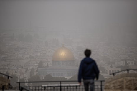 A silhouette of person looking at a view of al-Aqsa mosque surrounded by a cloud of dust due to a sandstorm in Jerusalem on Thursday.
