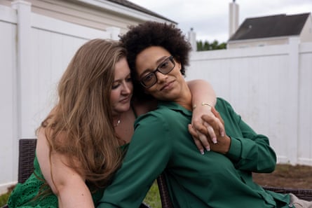 Priscilla and Kiara sitting in their garden embracing one another
