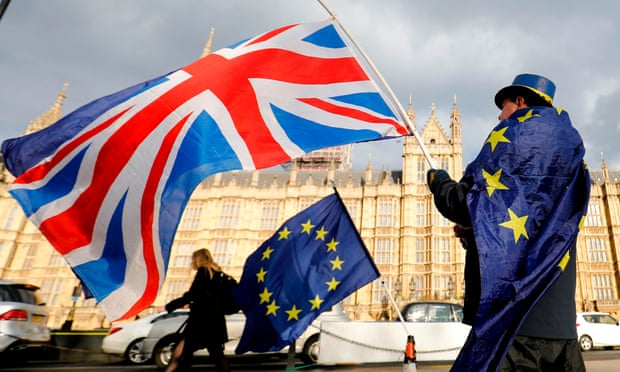 An anti-Brexit demonstrator waves a Union flag alongside a European Union flag outside the Houses of Parliament in London