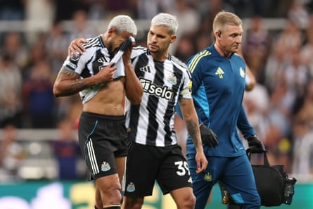 Bruno Guimarães consoles Joelinton as he leaves the field injured.