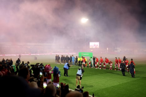 Οι παίκτες της Fleetwood Town και της Arsenal παρατάσσονται σε ένα καπνισμένο γήπεδο πριν από τον αγώνα τους στο Carabao Cup