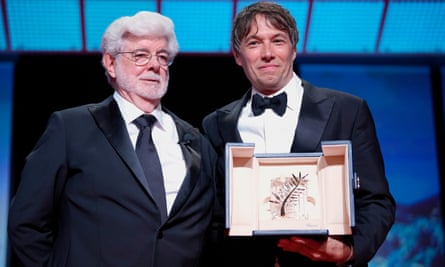 Sean Baker, right, holds the Palme d'Or for the film Anora, alongside George Lucas on Saturday.