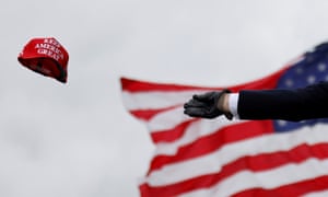 Donald Trump tosses out ‘Keep America Great’ caps at a campaign rally at Oakland County international airport in Waterford Township, Michigan, on 30 October 2020.