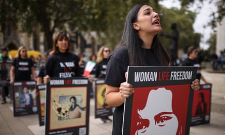 A group of women hold placards saying “Woman, Life, Freedom”